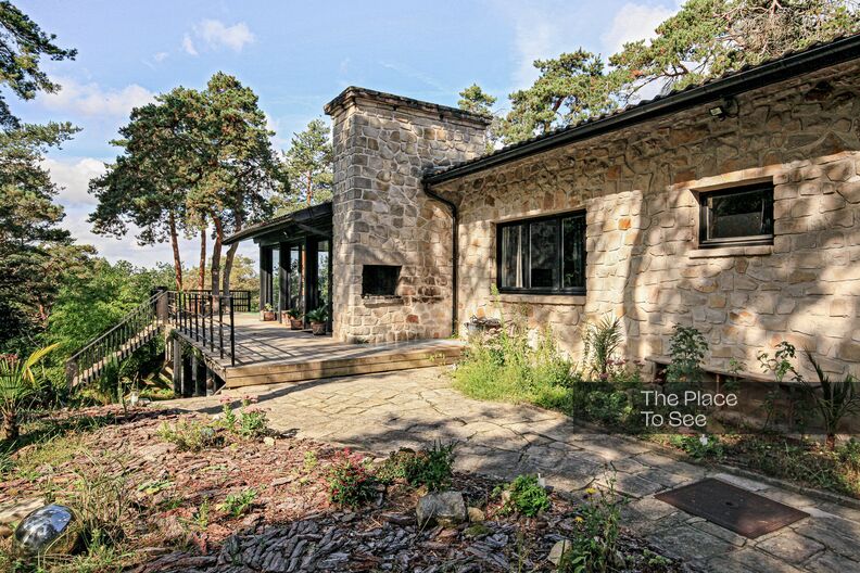 Maison d'architecte en bois et pierre dans la forêt