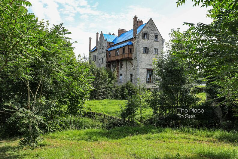 Faded 1850 mansion isolated in a park with private lake