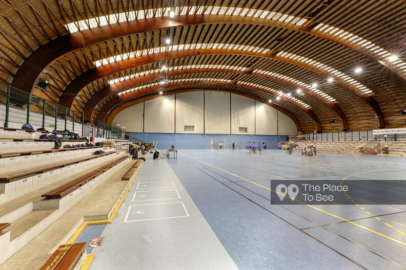 Wooden frame gymnasium with large corridors and colorful stained glass windows