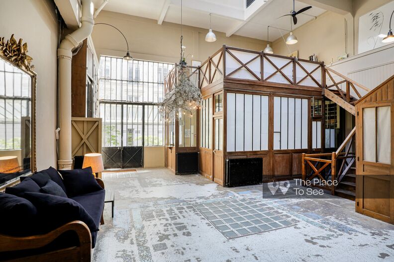 Industrial artist's studio in wood and brick with paved courtyard