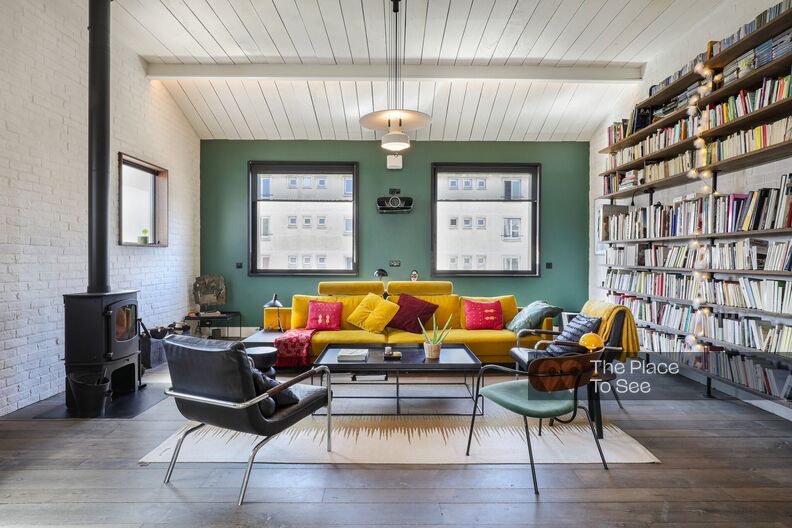 Colorful triplex loft with white brick walls and bay windows