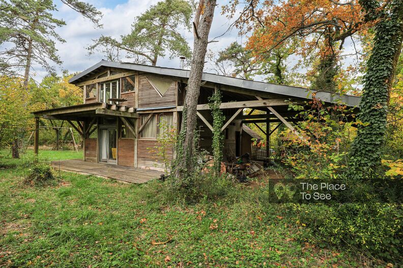 Maison bohème tout en bois isolée au milieu de la forêt