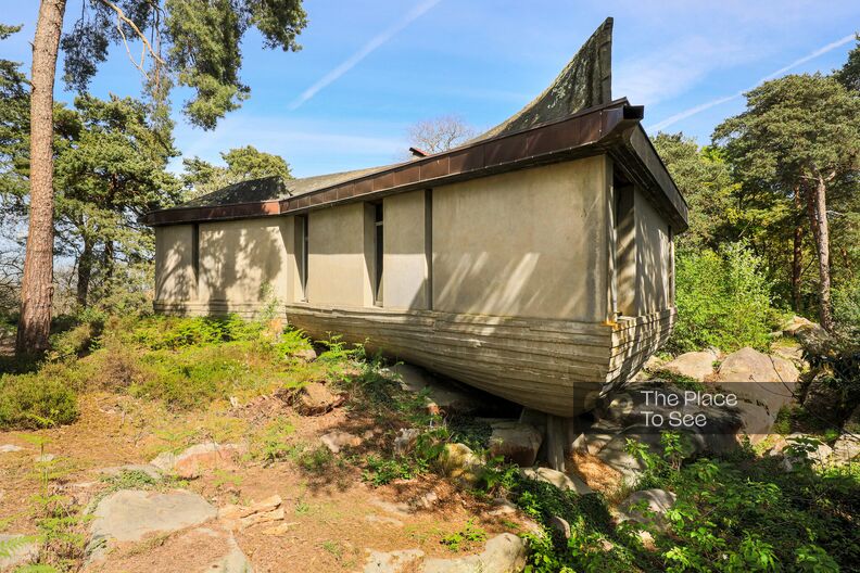 Maison brutaliste au sommet d'une forêt